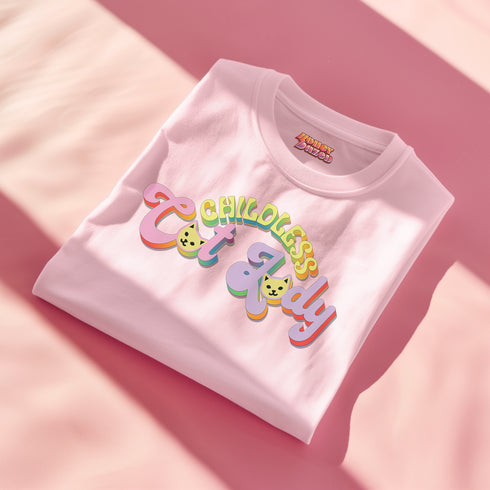 An election 2024 t-shirt with a colorful retro-style graphic that reads "Childless Cat Lady" across the chest. The text is in a playful, curvy font with each word in a different color - "Childless" in yellow-green, "Cat" in pink, and "Lady" in purple. Small cat face icons are incorporated into the letters 'a' in "Cat" and "Lady".