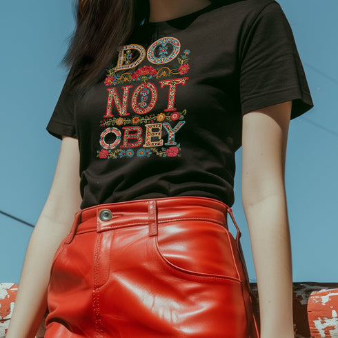 Black T-shirt with bold, embroidered-style text reading "Do Not Obey" surrounded by floral patterns.
