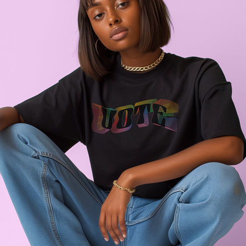 Election 2024 t-shirt with "VOTE" printed in large, colorful letters. Each letter features a different color from the rainbow spectrum, styled in a groovy 70s-inspired font.