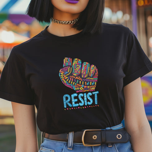 Black t-shirt with vibrant multicolored patterned raised fist graphic and blue "RESIST" text underneath. Rainbow activist protest shirt with psychedelic design elements on cotton-polyester blend.