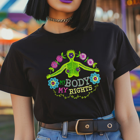 Black unisex t-shirt featuring "MY BODY MY RIGHTS" text with vibrant embroidery-style design of green skeleton figure and colorful flowers. Feminist pro-choice shirt with neon pink, blue, and yellow details available in sizes S-3XL in cotton-poly blend.