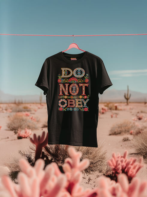 Black T-shirt with bold, embroidered-style text reading "Do Not Obey" surrounded by floral patterns.