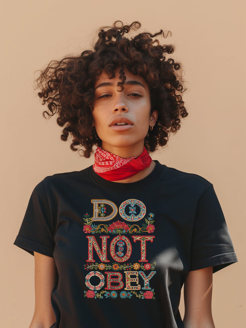 Black T-shirt with bold, embroidered-style text reading "Do Not Obey" surrounded by floral patterns.