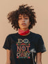 Black T-shirt with bold, embroidered-style text reading "Do Not Obey" surrounded by floral patterns.