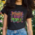 Black unisex t-shirt with colorful "POWER TO THE PEOPLE" text design in orange, pink, and green lettering surrounded by swirling psychedelic rainbow border.