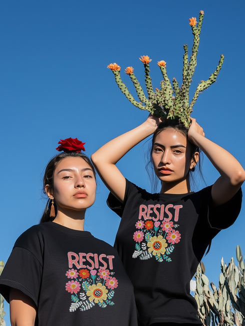 Black unisex t-shirt with "Resist" in bold, embroidered-style floral print. Political activism shirt with a vintage, handcrafted feel.