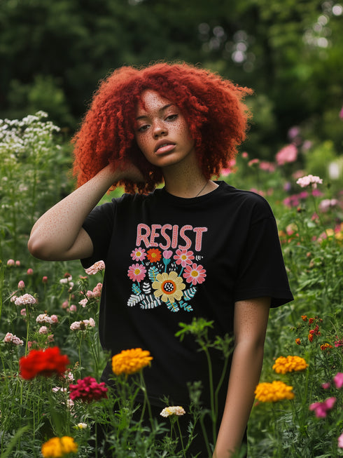 Black unisex t-shirt with "Resist" in bold, embroidered-style floral print. Political activism shirt with a vintage, handcrafted feel.