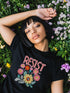 Black unisex t-shirt with "Resist" in bold, embroidered-style floral print. Political activism shirt with a vintage, handcrafted feel.