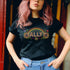 Black unisex t-shirt with "ALLY" in gold lettering under a rainbow arch, flanked by two large sunflower designs. LGBTQ+ pride ally shirt with folk art-inspired elements, available in cotton-poly blend, sizes S-3XL.