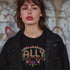 Black t-shirt featuring "ALLY" in gold letters protected by a rainbow arch and flanked by two sunflowers. LGBTQ+ pride ally shirt with colorful folk art-inspired design, available in cotton-poly blend, sizes S-3XL.