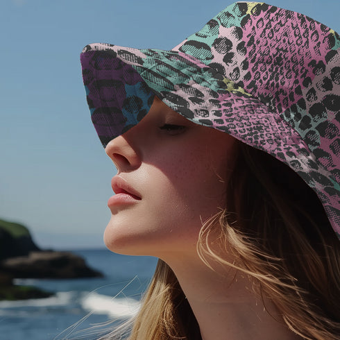Reversible bucket hat with colorful snakeskin print in pastel shades of pink, blue, and yellow