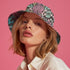 Reversible bucket hat with colorful snakeskin print in pastel shades of pink, blue, and yellow