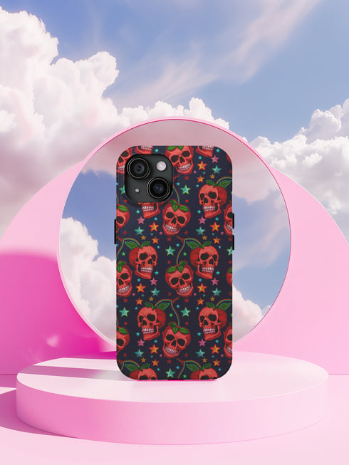 Phone case featuring vibrant red apple skulls with green stems and multicolored stars on navy background. Gothic alternative design with bright colorful accents.