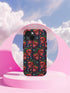 Phone case featuring vibrant red apple skulls with green stems and multicolored stars on navy background. Gothic alternative design with bright colorful accents.