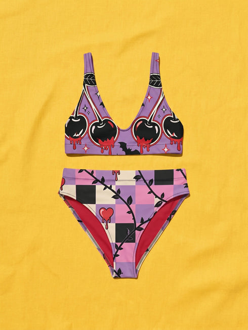 Two piece pastel goth bikini with a v neck top and high waisted bottom. The purple top is covered in large black cherries dripping red, tiny flying bats, and white sparkle stars. The high cut bottoms show a pink, lavender, black, and cream checkerboard overlaid with black thorny vines and dripping red hearts. Soft, stretchy recycled polyester fabric with UPF 50 sun protection and removable padding. Creepy cute whimsigoth swimwear for spooky summer pool days, haunted beach trips, and music festivals.