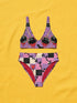 Two piece pastel goth bikini with a v neck top and high waisted bottom. The purple top is covered in large black cherries dripping red, tiny flying bats, and white sparkle stars. The high cut bottoms show a pink, lavender, black, and cream checkerboard overlaid with black thorny vines and dripping red hearts. Soft, stretchy recycled polyester fabric with UPF 50 sun protection and removable padding. Creepy cute whimsigoth swimwear for spooky summer pool days, haunted beach trips, and music festivals.