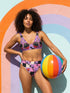 Two piece pastel goth bikini with a v neck top and high waisted bottom. The purple top is covered in large black cherries dripping red, tiny flying bats, and white sparkle stars. The high cut bottoms show a pink, lavender, black, and cream checkerboard overlaid with black thorny vines and dripping red hearts. Soft, stretchy recycled polyester fabric with UPF 50 sun protection and removable padding. Creepy cute whimsigoth swimwear for spooky summer pool days, haunted beach trips, and music festivals.