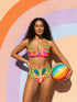 Vibrant two piece maximalist bikini with a v neck bralette top and high waisted bottom. The fabric mixes a bright yellow and hot pink gingham checkerboard with oversized neon pink and red cherries, green leaves, and semicircle watermelon shapes with white dots along the lower edge. Smooth, stretchy recycled polyester with UPF 50 sun protection and removable padding. Bold retro pop art swimwear in saturated dopamine colors, built for pool parties, vacation outfits, and fun beach days.