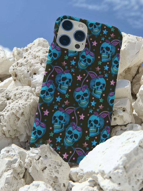 Black phone case featuring bright electric blue skulls with purple cherry stems and colorful stars scattered throughout the pattern. Gothic yet playful design.