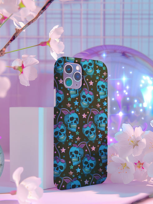 Black phone case featuring bright electric blue skulls with purple cherry stems and colorful stars scattered throughout the pattern. Gothic yet playful design.