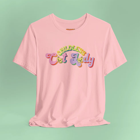 An election 2024 t-shirt with a colorful retro-style graphic that reads "Childless Cat Lady" across the chest. The text is in a playful, curvy font with each word in a different color - "Childless" in yellow-green, "Cat" in pink, and "Lady" in purple. Small cat face icons are incorporated into the letters 'a' in "Cat" and "Lady".