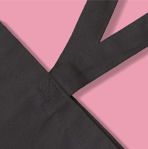 Canvas tote bag featuring pink skull cherries design. Two pink skulls connected by red stem and bow. Quirky gothic-inspired graphic on cream background. Stylish, edgy accessory for everyday use. Perfect for alternative fashion lovers.