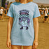 Unisex Comfort Colors 1717 t-shirt featuring a front print of a cute gothic ghost holding a mace wand with text reading "Fight Like A Ghoul." The ghost has floral details, combat boots, and pastel accents. Made of soft-washed, 100% ring-spun cotton with garment-dyed fabric and seamless tubular knit construction. Available in sizes S to 4XL.