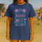 Comfort Colors 1717 unisex garment-dyed t-shirt featuring a front floral graphic with the word RESIST in pink block letters surrounded by green vines, purple roses, skulls, moons, and daggers. Made of soft-washed 100% ring-spun cotton with tubular knit construction, available in sizes S to 4XL.