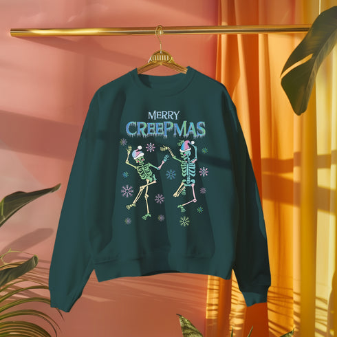 A dark green holiday sweatshirt featuring two dancing skeletons wearing Santa hats. The text "Merry Creepmas" is displayed above them in icy, drippy font. The design is surrounded by colorful snowflakes, blending spooky and festive elements for a fun, alternative holiday look.