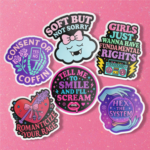 Feminist sticker sheet measuring 9.8x14 inches featuring 6 kiss-cut vinyl stickers with matte finish. Includes designs: “Consent or Coffin” (4.1x4), “Girls Just Wanna Have Fundamental Rights” (3.5x4.1), “Hex the System” (3.6x3.7), “Romanticize Your Rage” (3.7x3.3), “Tell Me to Smile and I’ll Scream” (3.6x3.6), and “Soft But Not Sorry” (~3.3"). Weather-resistant, semi-permanent adhesive, ideal for laptops, water bottles, and journals.