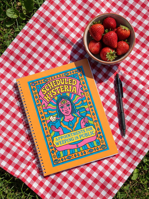 Undated weekly planner with hardcover and metal wire-o spiral binding options in black or gold. Cover features retro pop art illustration of a three-eyed woman crying while holding wine and tissues, with text Scheduled Hysteria. Vibrant orange background with psychedelic blue and purple patterns. Open planner shows flexible weekly layout on high-quality 60lb paper. Lays flat for easy writing. Ideal for ADHD organization, funny mental health gifts, and maximalist desk decor. Satin matte finish.