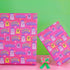 Bright pink christmas wrapping paper covered in cute ghost characters wearing Santa hats, with "Haunted Holiday" and "Boo Humbug" text, and snowflake accents.