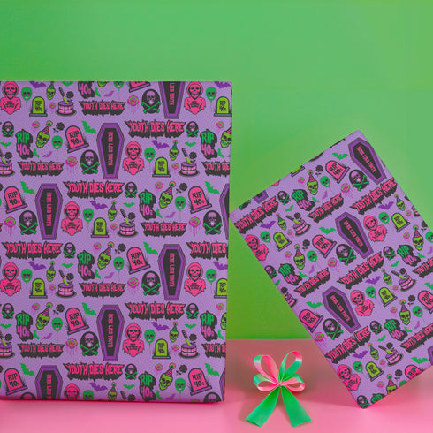 Vibrant purple wrapping paper with gothic-inspired design for 50th birthdays. Features colorful skulls wearing party hats, coffins, 'RIP 40s' tombstones, and 'Youth Dies Here' text. Perfect for edgy, humorous gifts to 50-year-olds.