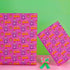Vibrant pink wrapping paper featuring Occult symbol Baphomet Santas throwing horns, surrounded by flaming pentagrams and "All Hail Santa" text. A punk rock twist on Christmas gift wrap.