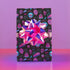 Spooky birthday wrapping paper with neon pink skulls, blue coffins, eyeballs, and bats on black background. Vibrant and gothic design for unique gift presentation.