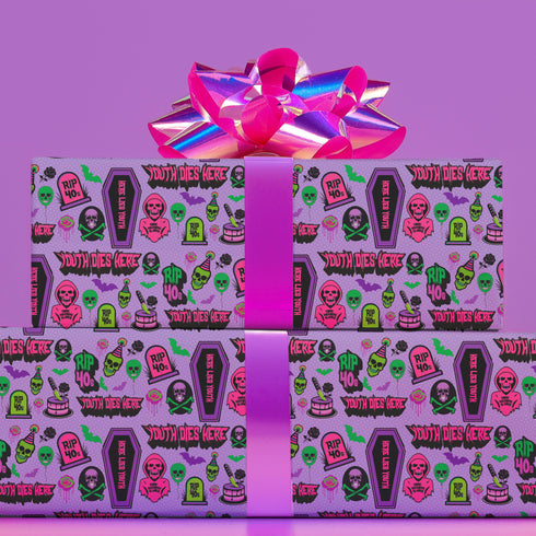 Vibrant purple wrapping paper with gothic-inspired design for 50th birthdays. Features colorful skulls wearing party hats, coffins, 'RIP 40s' tombstones, and 'Youth Dies Here' text. Perfect for edgy, humorous gifts to 50-year-olds.