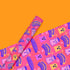 Bright pink christmas wrapping paper covered in cute ghost characters wearing Santa hats, with "Haunted Holiday" and "Boo Humbug" text, and snowflake accents.
