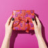 Vibrant pink wrapping paper featuring Occult symbol Baphomet Santas throwing horns, surrounded by flaming pentagrams and "All Hail Santa" text. A punk rock twist on Christmas gift wrap.