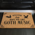 Tan coir doormat featuring "Welcome, Hope You Like Goth Music" in black text, with bat and skull imagery and gothic-style corner decorations.