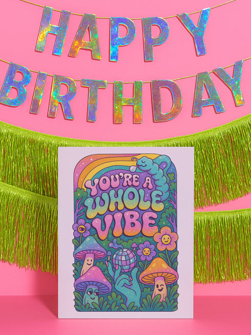 5x7 inch greeting card featuring colorful psychedelic artwork with smiling mushrooms, pastel rainbow, disco ball, flowers, and a blue slug. The inside reads: “Keep blooming, keep weirding. You’re exactly the kind of strange this world needs.” Printed on silk cover stock with a soft glossy finish and includes a white envelope