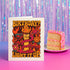 5x7 inch birthday greeting card featuring a bold psychedelic design with a snake wrapped around a melting candle, flames, mushrooms, and planets in red, orange, and pink tones. The card includes a white envelope and an interior message that reads, "One more year of burning brighter and giving zero f*cks." Printed on glossy silk stock.