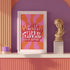 Retro-style poster with psychedelic 1970s-inspired design. Text reads "WEIRD GIRLS DO IT BETTER" in wavy, groovy lettering. Pink and orange sunburst background. Centered text surrounded by curved rays. Bold red frame with scalloped edges. Vibrant colors and playful typography create a vintage hippie vibe. Square format print with rounded corners. Perfect for fans of retro aesthetics and empowering slogans.