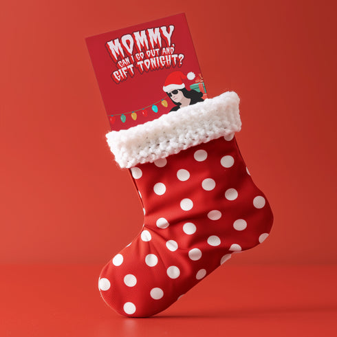 Punk rock Christmas card featuring Glenn Danzig-inspired figure in Santa hat, surrounded by presents. Text reads "Mommmy, can I go out and gift tonight?" Perfect for alternative holiday greetings.