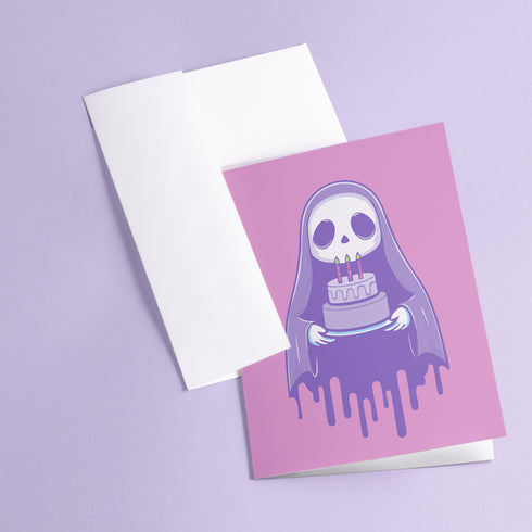 Birthday card featuring a cute cartoon grim reaper holding a birthday cake on pink background. The reaper wears a purple cloak and has a white skull face. It's carrying a small purple cake with three lit candles. The reaper's cloak drips like melting icing at the bottom. Ideal for Halloween birthdays or gothic-themed celebrations. Inside greeting: "Hope your B-day is spooky AF and sweet as cake!"
