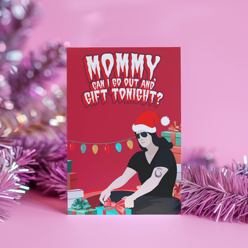 Punk rock Christmas card featuring Glenn Danzig-inspired figure in Santa hat, surrounded by presents. Text reads "Mommmy, can I go out and gift tonight?" Perfect for alternative holiday greetings.