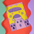 Christmas card with a playful ghost theme. Central cute pink ghost wearing a purple Santa hat, flanked by two smaller purple ghosts. Yellow background with snowflakes. Text reads "Boo HUMBUG" in purple bubble letters. Blends Christmas and Halloween elements for a unique holiday greeting. Inside message: "May your Christmas be filled with delight, not fright.
