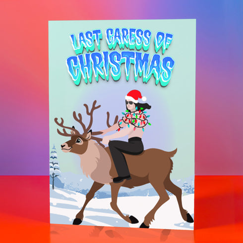 A humorous holiday card featuring an illustration of Glenn Danzig from the Misfits riding a reindeer, wearing a Santa hat and wrapped in Christmas lights. The text at the top reads "Last Caress of Christmas" in icy blue letters, referencing the iconic Misfits song. The background depicts a snowy winter scene, combining punk rock and festive elements for a playful twist.