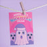 Holiday card with pink background featuring cartoon ghosts. Main ghost wears purple Santa hat. Text reads "WISHING YOU A HAUNTED HOLIDAY" in colorful, playful font. Overall cute and spooky design blending Halloween and Christmas themes. Inside message: "Eat, Drink, and Be Scary.