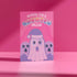 Holiday card with pink background featuring cartoon ghosts. Main ghost wears purple Santa hat. Text reads "WISHING YOU A HAUNTED HOLIDAY" in colorful, playful font. Overall cute and spooky design blending Halloween and Christmas themes. Inside message: "Eat, Drink, and Be Scary.