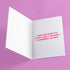 Quirky Christmas card featuring grim reaper in Santa hat. Pink background with bats, snowflakes, skull motifs. Text reads 'Grave Tidings We Bring'. Humorous blend of holiday cheer and gothic aesthetic. Perfect for alternative Christmas greetings.